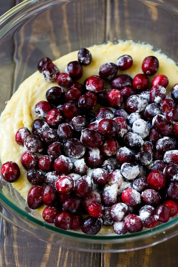 Cranberry Bread Recipe | Cranberry Loaf | Cranberry Orange Bread #cranberry #bread #baking #dessert #fall #sadud Orange batter topped with a pile of fresh cranberries in a mixing bowl.