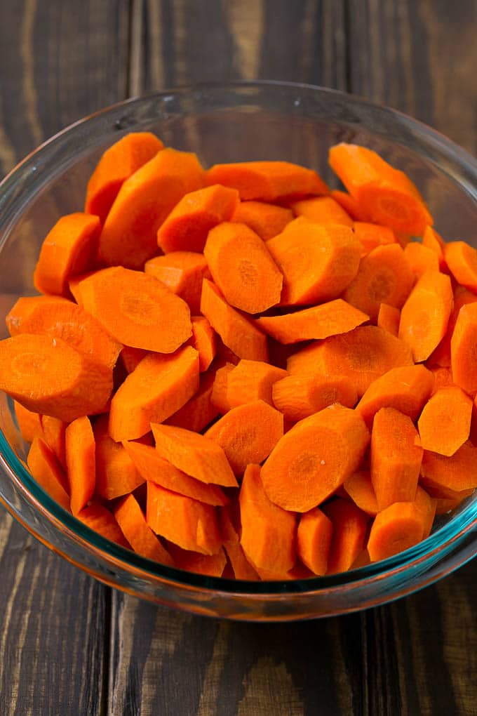 Glazed Carrots Recipe | Brown Sugar Carrots | Carrot Side Dish #carrots #brownsugar #sidedish #glutenfree #thanksgiving #fall #dinner #sadud A bowl of peeled and sliced carrots.