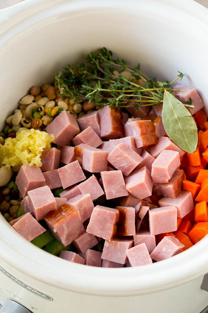 Ham and Bean Soup Recipe | Slow Cooker Ham and Bean Soup | Crockpot Ham and Bean Soup | Leftover Ham Recipe #ham #beans #soup #slowcooker #crockpot #dinner #sadud Vegetables, pork, herbs and garlic in the slow cooker.