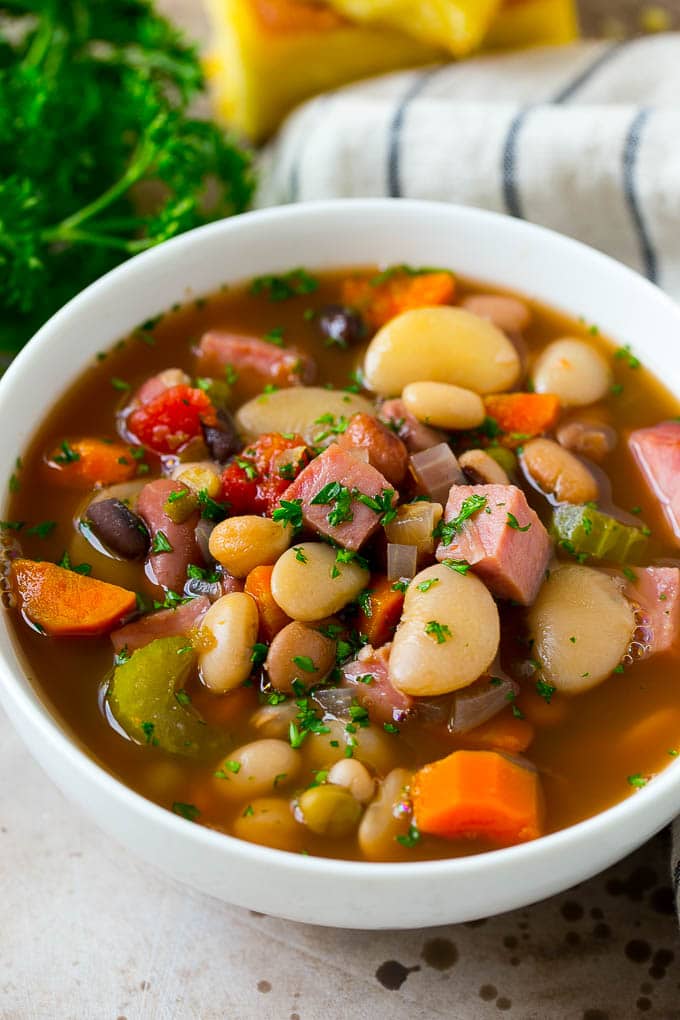 Ham and Bean Soup Recipe | Slow Cooker Ham and Bean Soup | Crockpot Ham and Bean Soup | Leftover Ham Recipe #ham #beans #soup #slowcooker #crockpot #dinner #sadud A bowl of ham and bean soup made with dried beans, ham and vegetables, then topped with fresh parsley.