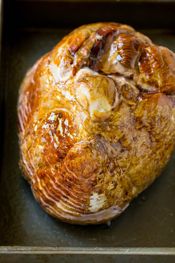 Honey Baked Ham Recipe | Glazed Ham | Holiday Ham #ham #dinner #sadud #christmas #thanksgiving #easter A honey coated ham, face down, in a baking dish.