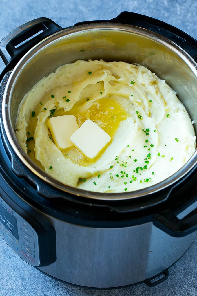 Instant Pot Mashed Potatoes Recipe | Pressure Cooker Mashed Potatoes | Easy Mashed Potatoes #potatoes #sidedish #instantpot #thanksgiving #dinner #sadud Instant Pot mashed potatoes with butter and chives inside a pressure cooker.