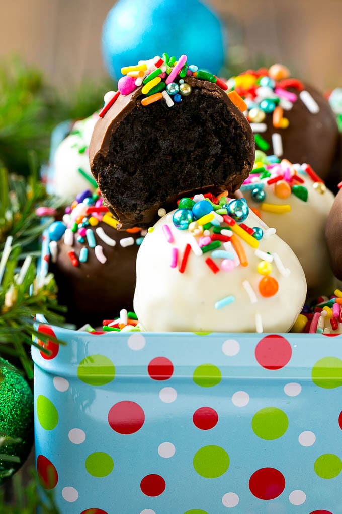Oreo Balls Recipe | Oreo Truffles | Homemade Candy #truffles #candy #oreos #chocolate #sprinkles #dessert #christmas #sadud A cross section of an Oreo ball inside a holiday gift tin.