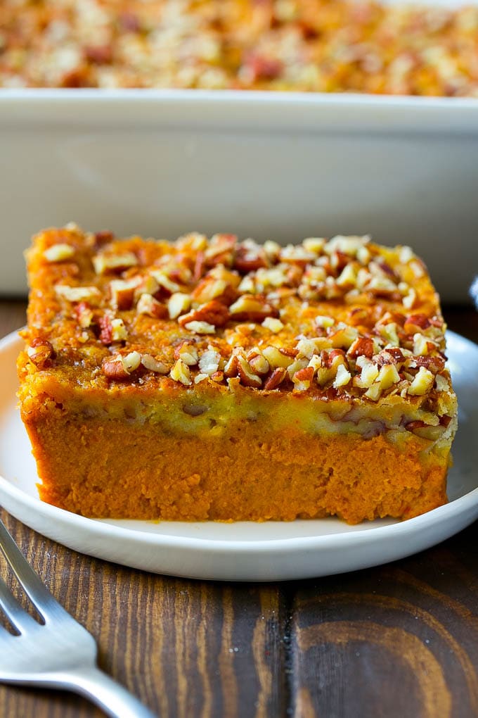 Pumpkin Dump Cake Recipe | Pumpkin Cake | Pumpkin Pie Cake #pumpkin #cake #pecans #fall #thanksgiving #dessert #sadud A slice of pumpkin dump cake topped with pecans.
