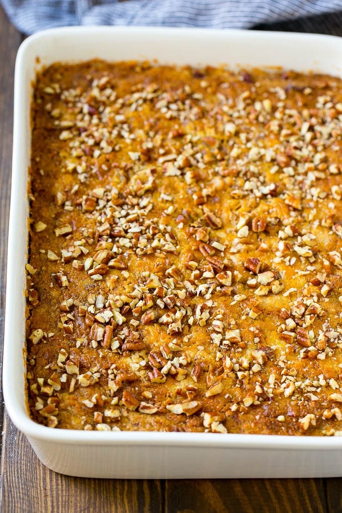 Pumpkin Dump Cake Recipe | Pumpkin Cake | Pumpkin Pie Cake #pumpkin #cake #pecans #fall #thanksgiving #dessert #sadud A pan of pumpkin dump cake topped with chopped pecans.