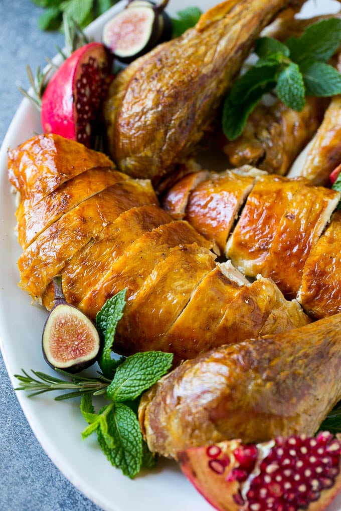 Roast Turkey Recipe | Thanksgiving Turkey | Holiday Turkey | Baked Turkey #turkey #thanksgiving #christmas #dinner #glutenfree #sadud Sliced roast turkey on a serving platter with rosemary, pomegranate and figs.