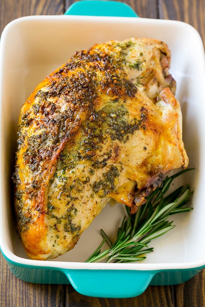 This roasted turkey breast is coated in a savory garlic and herb butter, then baked to golden brown perfection. A roasted turkey breast in a baking dish.