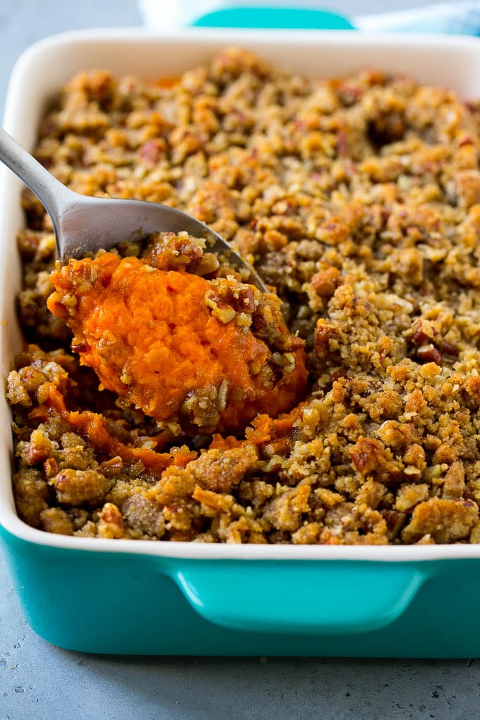 Ruth's Chris Sweet Potato Casserole Recipe | Sweet Potato Casserole | Mashed Sweet Potatoes #sweetpotatoes #casserole #thanksgiving #christmas #holidays #dinner #sadud #sidedish Ruth's Chris sweet potato casserole with a serving spoon in it.