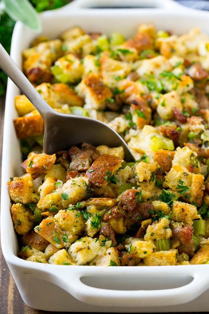 Sausage Stuffing Recipe | Thanksgiving Stuffing | Make Ahead Stuffing #stuffing #thanksgiving #sausage #sidedish #dinner #sadud A baking dish of sausage stuffing with a serving spoon in it.