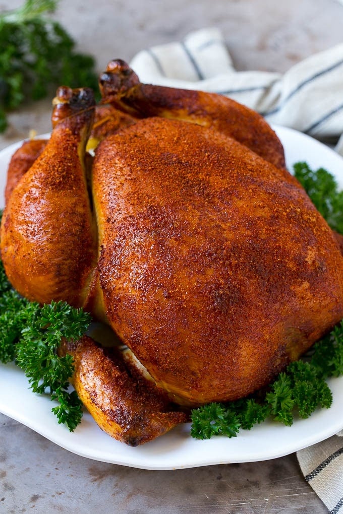 Smoked Chicken Recipe | Whole Smoked Chicken | BBQ Chicken #chicken #smoker #BBQ #dinner #sadud #glutenfree #lowcarb Smoked chicken on a serving platter garnished with parsley.