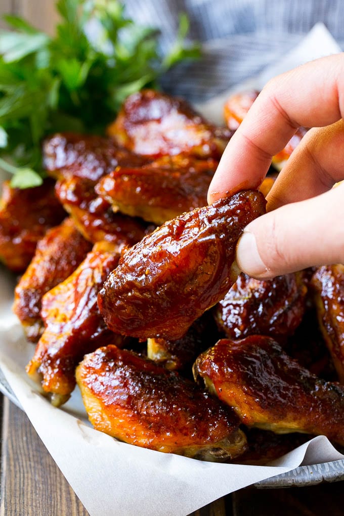 Smoked Chicken Wings | Barbecue Chicken Wings | BBQ Chicken Wings #chicken #wings #bbq #barbecue #appetizer #dinner #sadud A pile of smoked chicken wings with a hand reaching out for one.