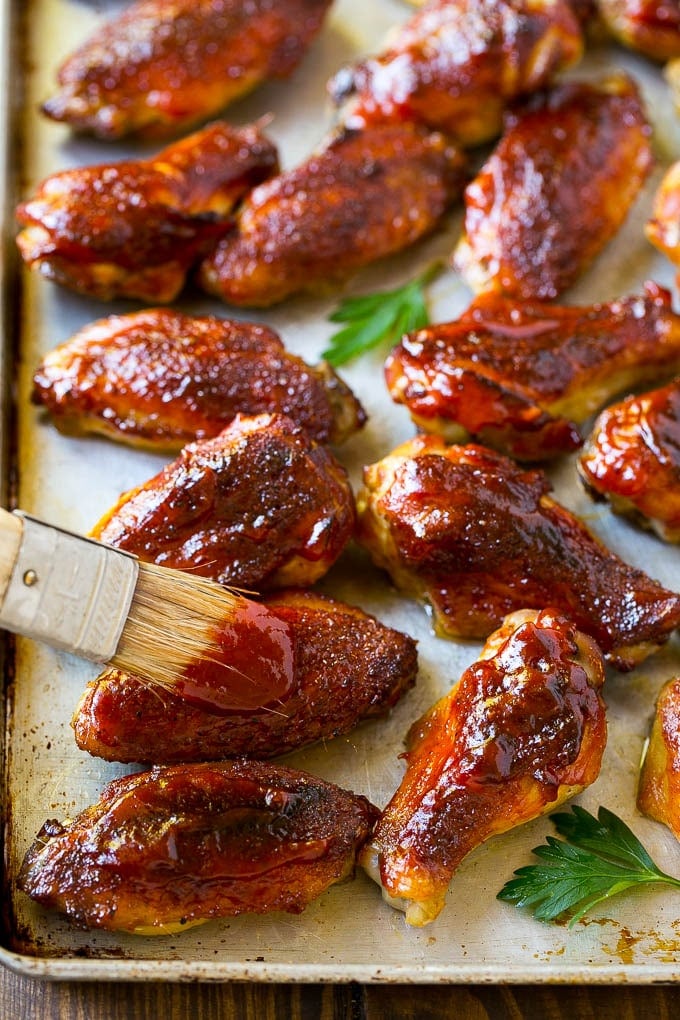 Smoked Chicken Wings | Barbecue Chicken Wings | BBQ Chicken Wings #chicken #wings #bbq #barbecue #appetizer #dinner #sadud BBQ sauce brushed onto a sheet pan of smoked chicken wings.