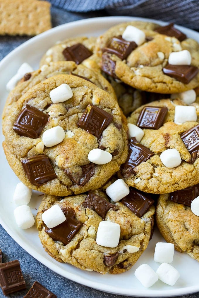 S'mores Cookies Recipe | Marshmallow Cookies #smores #marshmallow #chocolate #cookies #dessert #sadud A plate of S'mores cookies topped with milk chocolate bars and marshmallows.