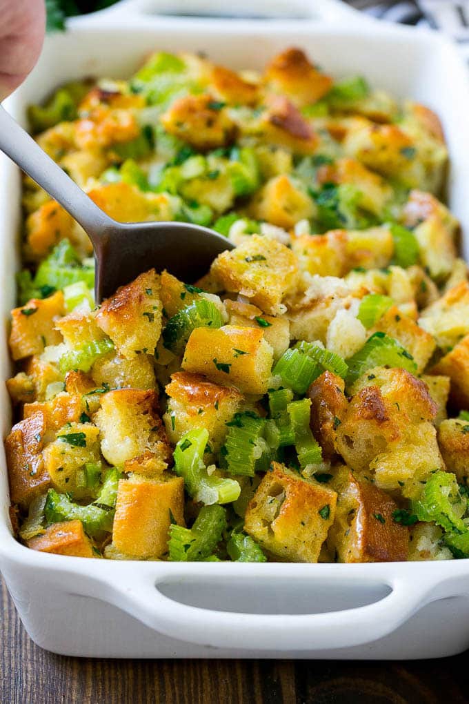 Turkey Stuffing Recipe | Thanksgiving Stuffing | Classic Stuffing #thanksgiving #stuffing #sidedish #fall #sadud Turkey stuffing in a casserole dish with a serving spoon in it.