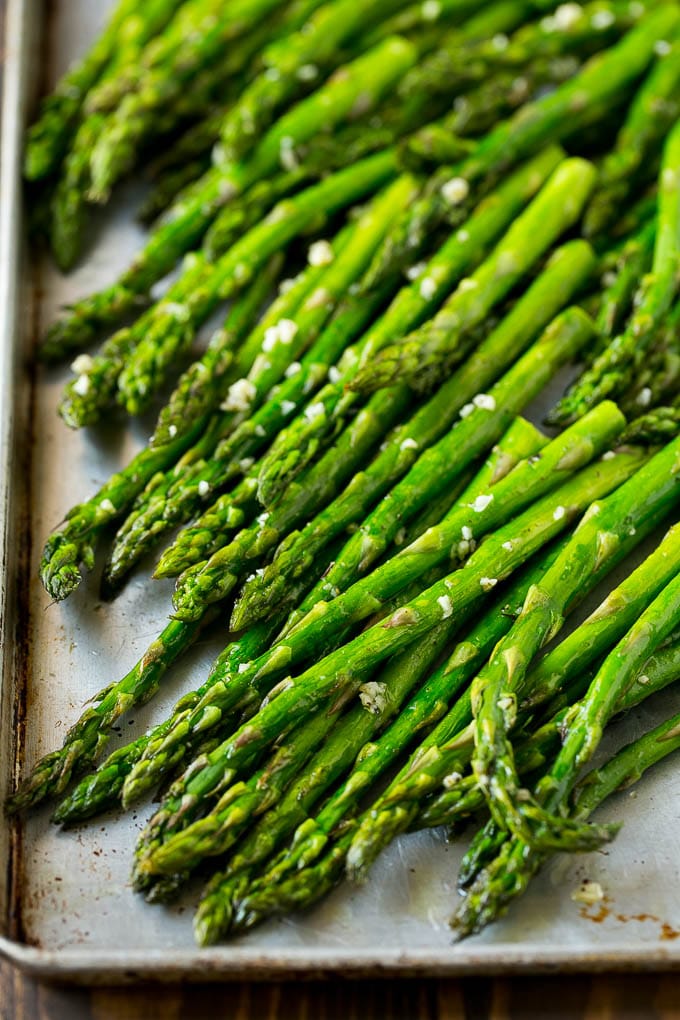 Roasted Asparagus Recipe | Baked Asparagus | Asparagus Side Dish #asparagus #garlic #sidedish #keto #lowcarb #dinner #sadud Roasted stalks with garlic and olive oil on a baking sheet.