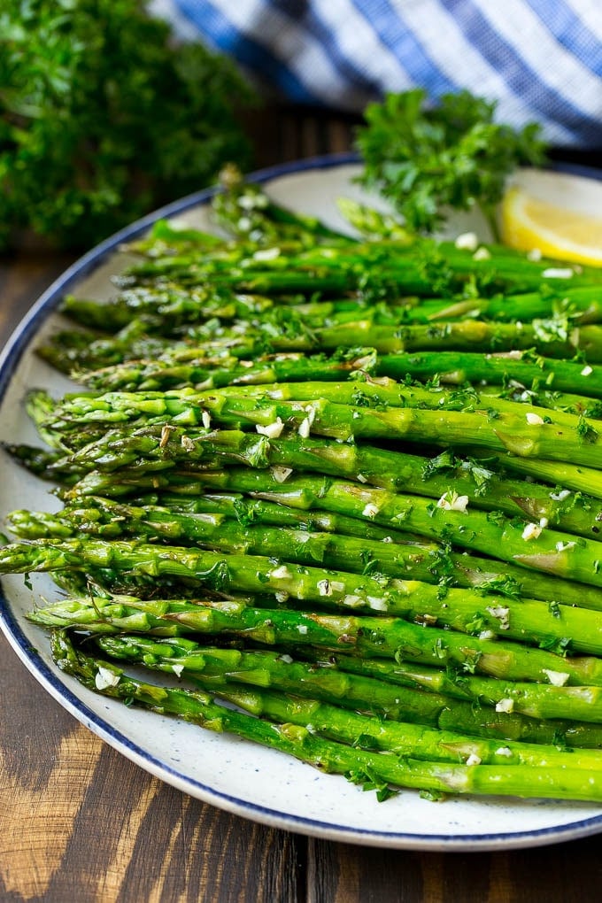 Roasted Asparagus Recipe | Baked Asparagus | Asparagus Side Dish #asparagus #garlic #sidedish #keto #lowcarb #dinner #sadud A serving plate of roasted asparagus topped with chopped parsley.