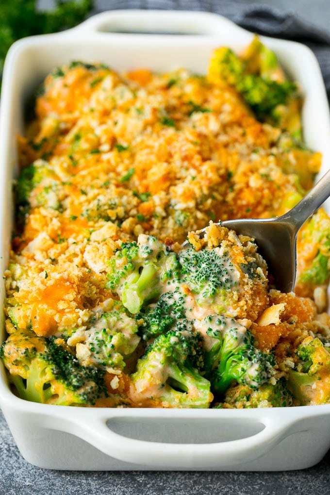 Broccoli Casserole Recipe | Broccoli and Cheese Casserole | Baked Broccoli #broccoli #cheese #casserole #sidedish #dinner #sadud A pan of broccoli casserole with a serving spoon in it.