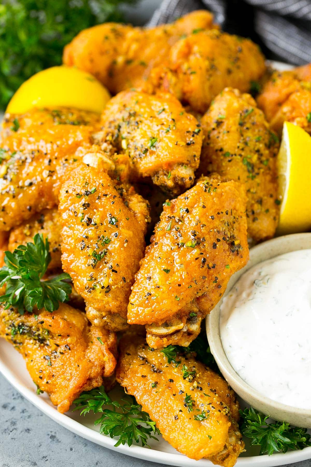 A plate of lemon pepper wings served with ranch.