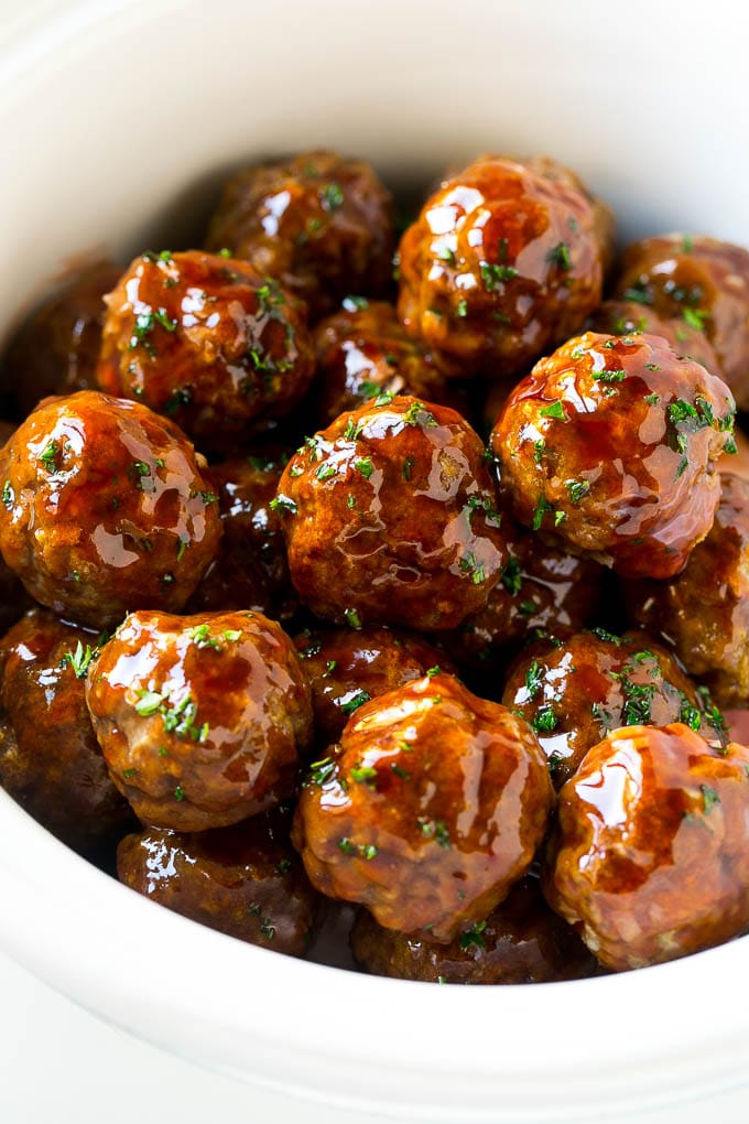 Sweet and Sour Meatballs Recipe | Slow Cooker Meatballs | Crockpot Meatballs | Cocktail Meatballs #meatballs #beef #slowcooker #crockpot #dinner #appetizer #sadud Sweet and sour meatballs garnished with parsley in a slow cooker.