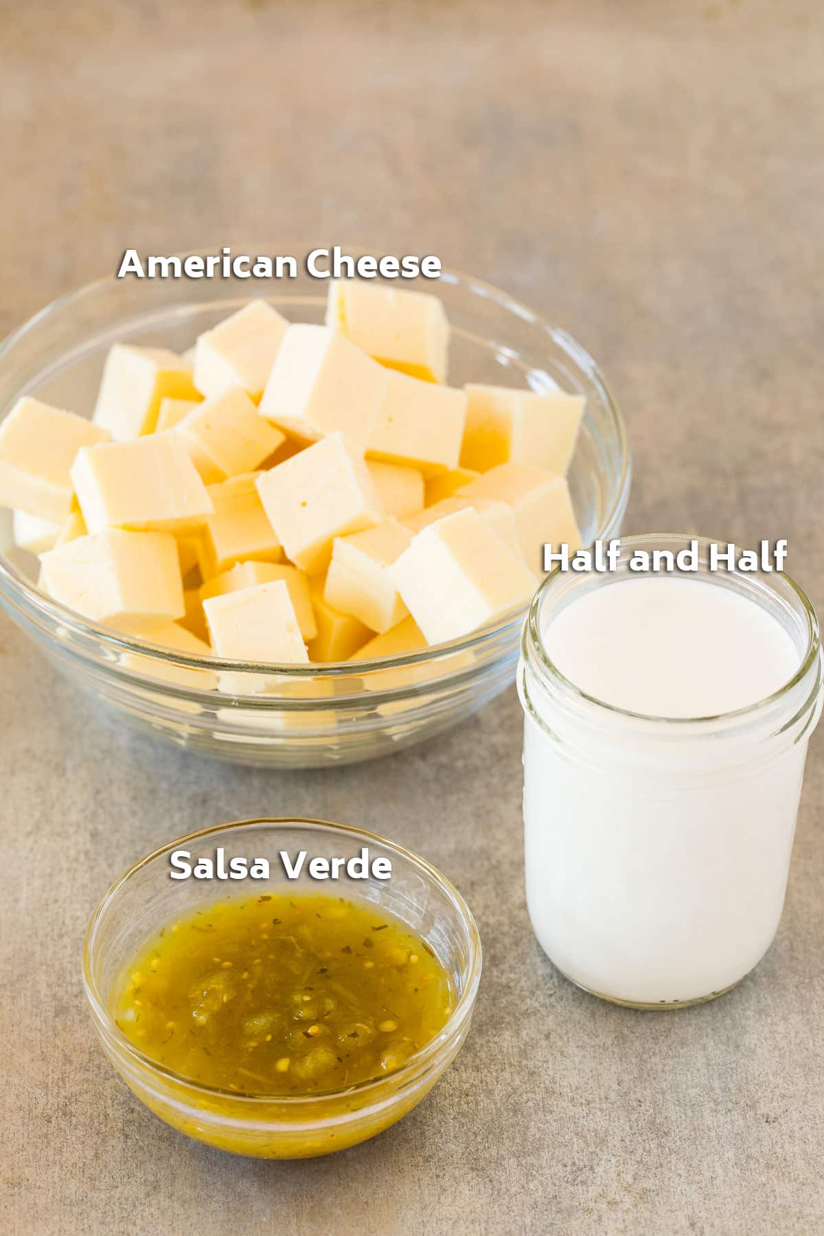 Bowls of ingredients including cheese cubes, half and half, and salsa.