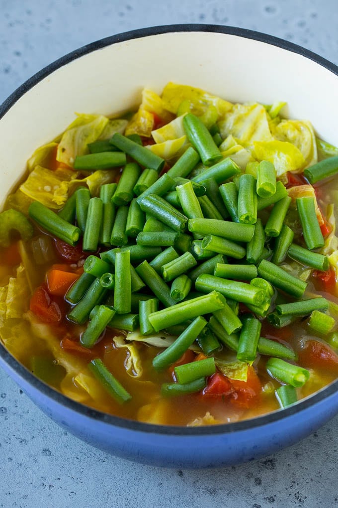 Cabbage Soup Recipe | Vegetable Soup | Veggie Soup | Healthy Soup #soup #healthy #cleaneating #cabbage #vegetables #veggies #dinner #sadud Green beans in a pot of cooked veggies.