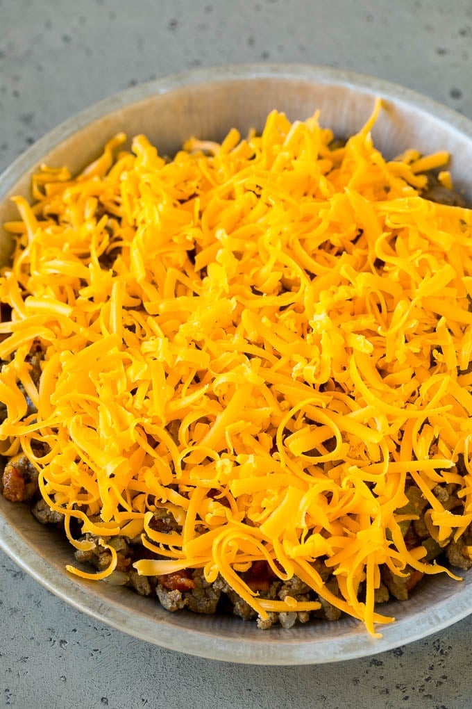 Cheeseburger Pie Recipe | Cheeseburger Casserole | Ground Beef Recipe #cheeseburger #beef #bacon #cheese #casserole #dinner #sadud Ground beef and shredded cheddar cheese in a dish.