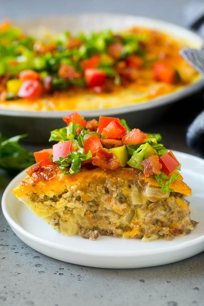 Cheeseburger Pie Recipe | Cheeseburger Casserole | Ground Beef Recipe #cheeseburger #beef #bacon #cheese #casserole #dinner #sadud A slice of cheeseburger pie garnished with shredded lettuce, diced tomatoes and pickles.