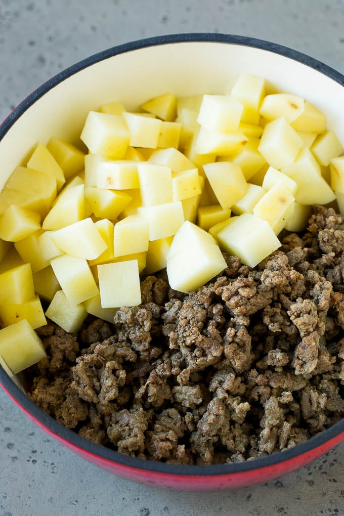 Cheeseburger Soup Recipe | Hamburger Soup | Cheese Soup #soup #groundbeef #hamburger #cheese #bacon #dinner #sadud Cooked ground beef and potatoes in a pot.