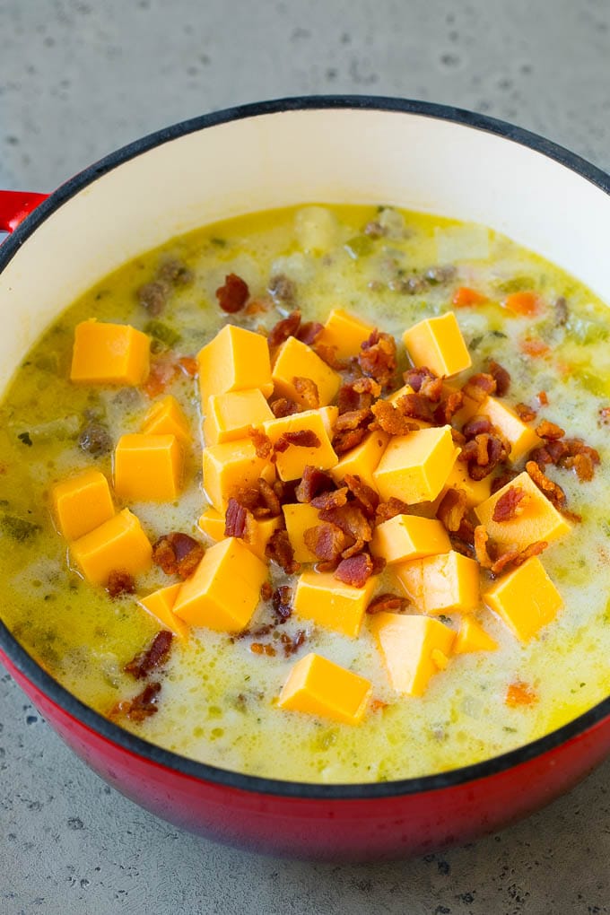 Cheeseburger Soup Recipe | Hamburger Soup | Cheese Soup #soup #groundbeef #hamburger #cheese #bacon #dinner #sadud Potato soup base with cubes of Velveeta cheese and bacon being stirred in.