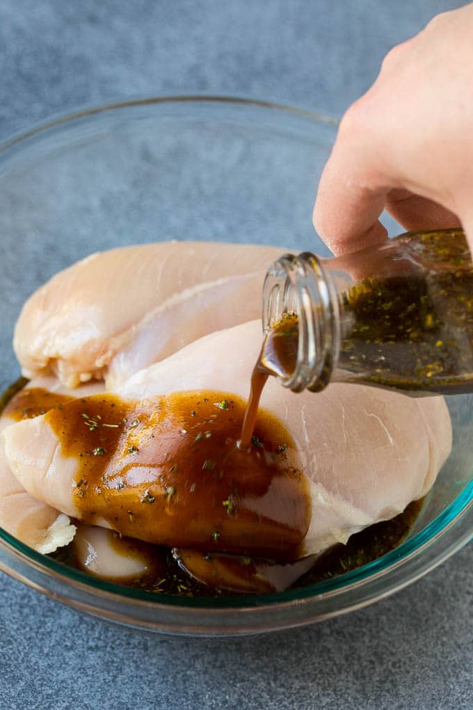 The best chicken marinade produces tender and juicy results every time! Chicken marinade being poured over skinless chicken breasts.
