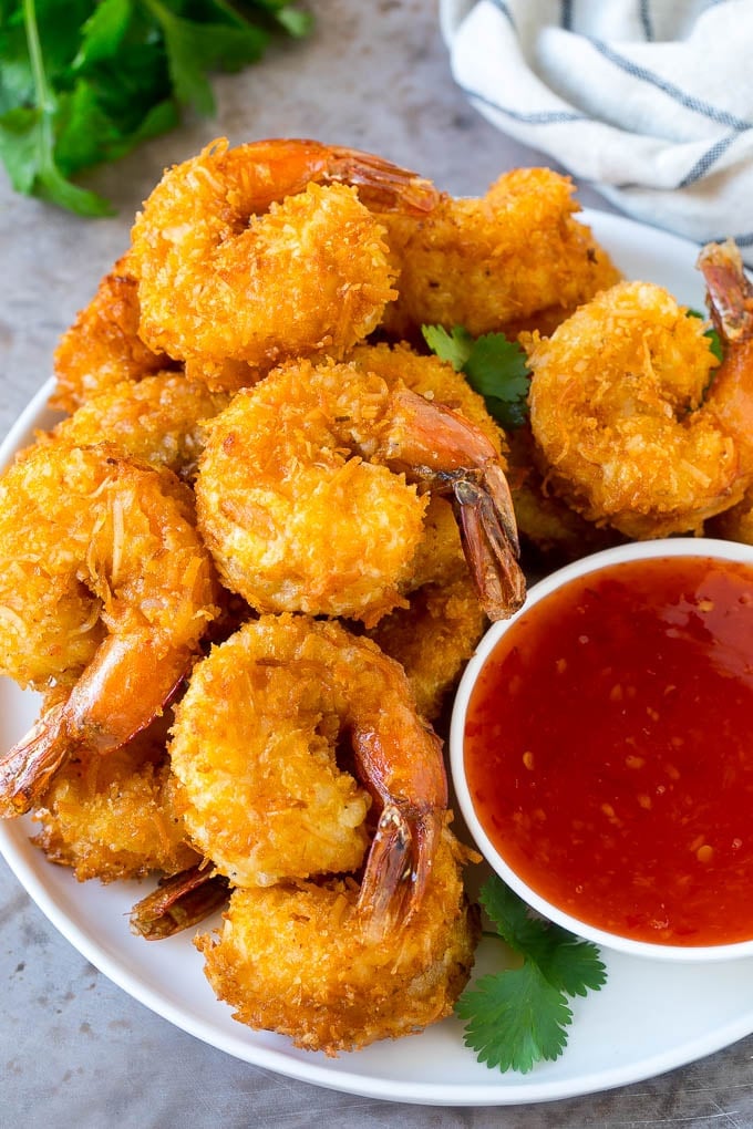 Coconut Shrimp Recipe | Fried Shrimp | Shrimp Appetizer #shrimp #coconut #appetizer #seafood #dinner #sadud A plate of coconut shrimp with a bowl of sweet chili sauce.