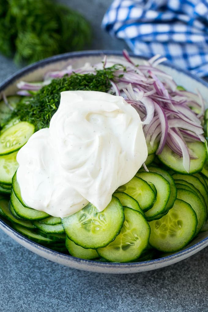 Creamy Cucumber Salad Recipe | German Cucumber Salad | Cucumber Salad #cucumber #salad #dinner #lunch #sadud #cucumbersalad Cucumbers, red onion and dill in a bowl topped with creamy dressing.