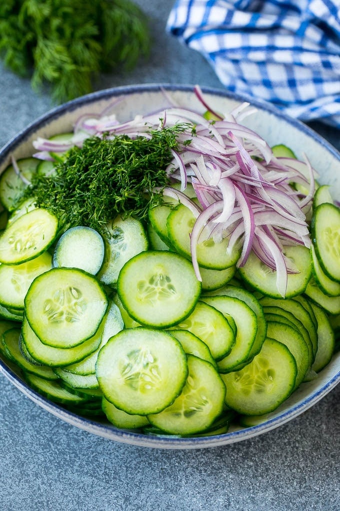 Creamy Cucumber Salad Recipe | German Cucumber Salad | Cucumber Salad #cucumber #salad #dinner #lunch #sadud #cucumbersalad Thinly sliced cucumbers, red onion and fresh dill in a mixing bowl.