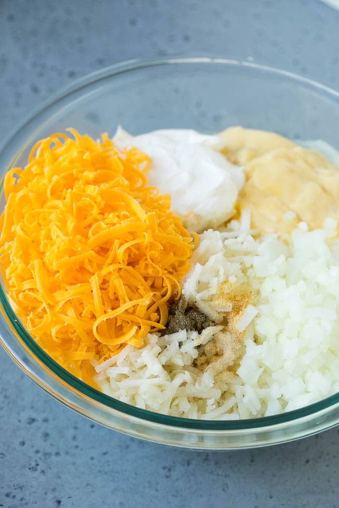 Hash Brown Casserole | Potato Casserole | Hash Brown Side Dish #potatoes #cheese #casserole #sidedish #sadud A bowl of potato shreds, cheese, cream of chicken soup, sour cream and seasonings.