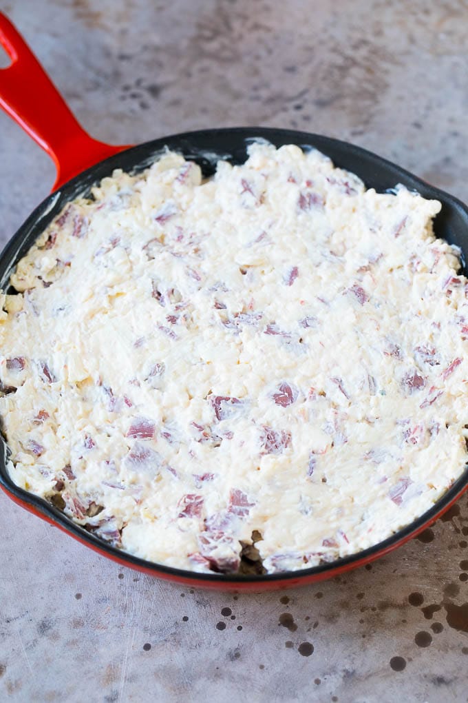 Reuben Dip Recipe | Corned Beef Dip | Cheese Dip #dip #cheese #cornedbeef #appetizer #lowcarb #keto #sadud Cream cheese, corned beef and other ingredients spread into a skillet for baking.