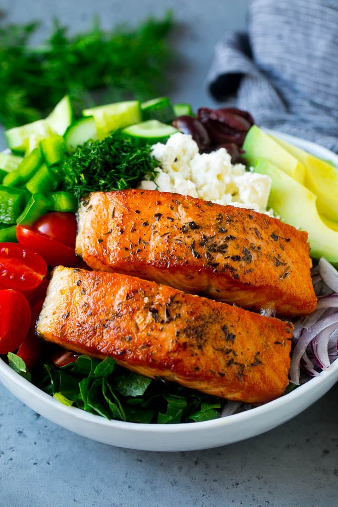 Greek Salmon Salad Recipe | Low Carb Salmon Recipe | Salmon Salad #salmon #seafood #fish #lowcarb #keto #lunch #sadud #healthy Salmon fillets on lettuce with tomatoes, feta cheese, avocado, olives, cucumbers and herbs.