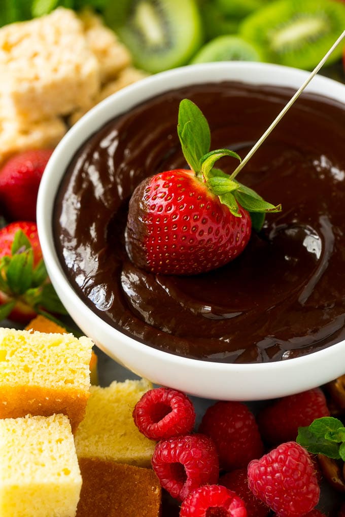 Chocolate Fondue Recipe | Chocolate Sauce | Chocolate Dip #chocolate #dessert #glutenfree #fondue #sadud A strawberry being dipped into a bowl of fondue.
