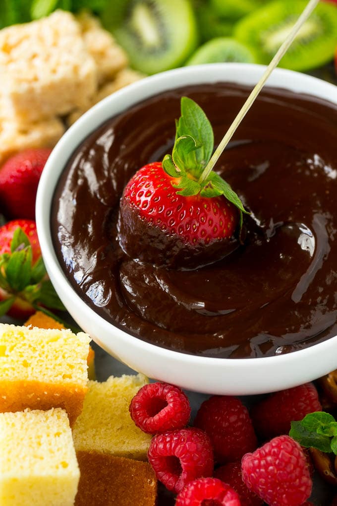 Chocolate Fondue Recipe | Chocolate Sauce | Chocolate Dip #chocolate #dessert #glutenfree #fondue #sadud A strawberry on a skewer dipped into a bowl of chocolate fondue.