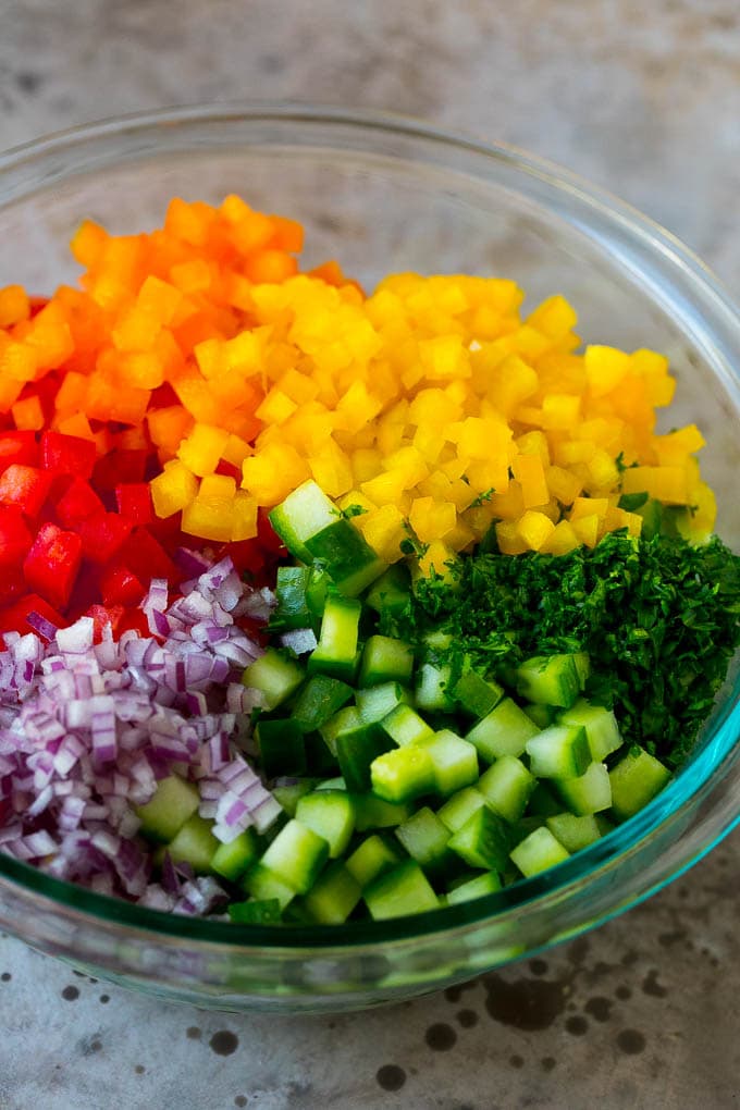Israeli Salad Recipe | Cucumber Salad | Tomato Salad | Chopped Salad #salad #cleaneating #healthy #glutenfree #lowcarb #keto #sidedish #lunch #sadud Chopped peppers, cucumbers, tomatoes and onions in a bowl.
