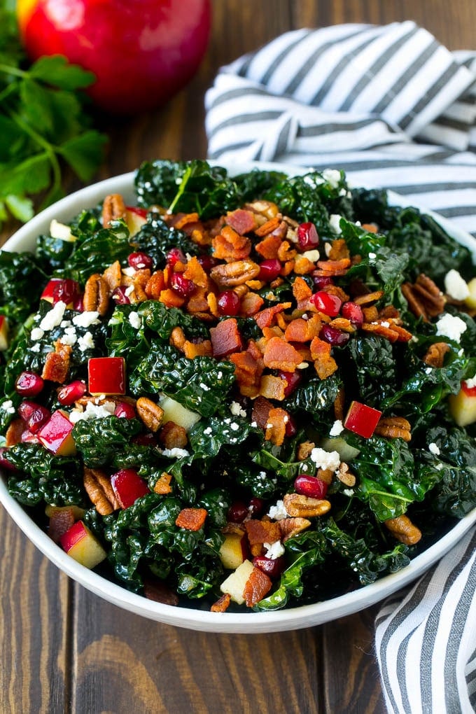 Apple Kale Salad Recipe | Kale Recipe | Fall Salad #kale #apples #bacon #salad #feta #dinner #lunch #sadud A bowl of tuscan kale salad garnished with cooked bacon.
