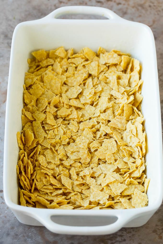 Taco Casserole Recipe | Mexican Casserole | Beef Casserole #casserole #tacos #beef #dinner #cheese #sadud Crushed tortilla chips in a casserole dish.