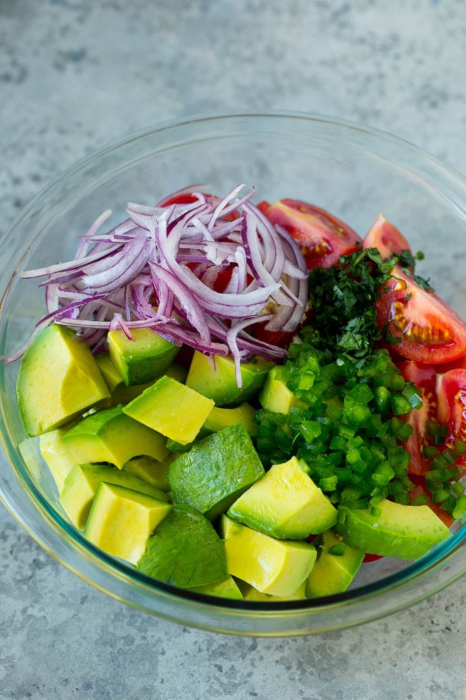 Tomato Avocado Salad Recipe | Avocado Salad | Tomato Salad #salad #tomato #avocado #glutenfree #cleaneating #dinner #sadud #healthy Pieces of avocado, tomato, red onion and minced jalapeno in a salad bowl.