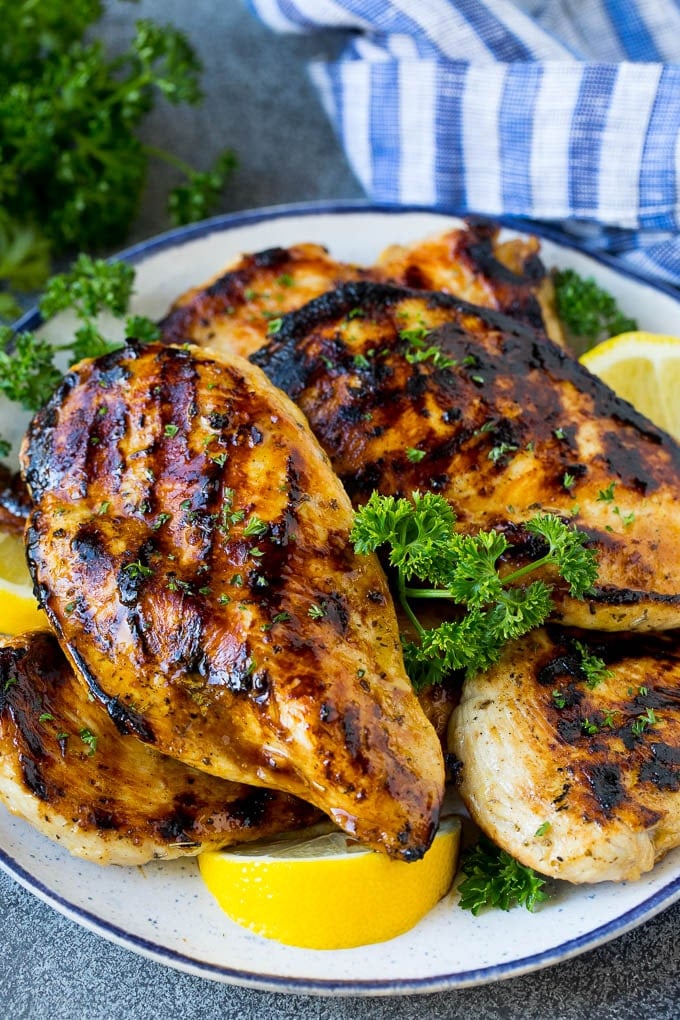 The best chicken marinade produces tender and juicy results every time! The best chicken marinade covering grilled chicken breasts, garnished with lemon.