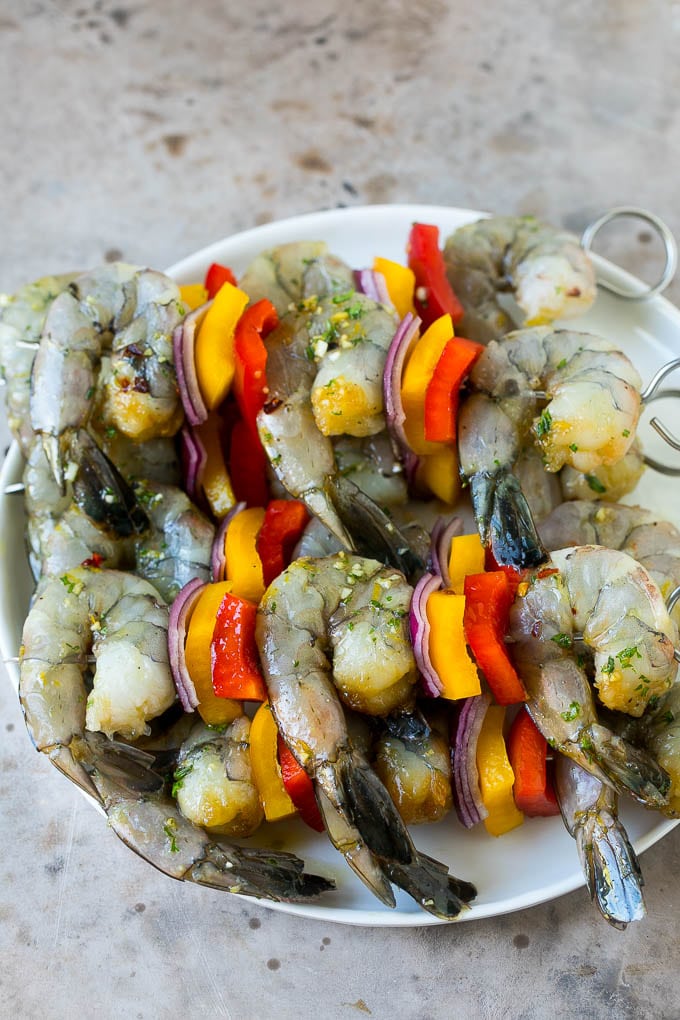 Raw shrimp on skewers with bell peppers and onions.