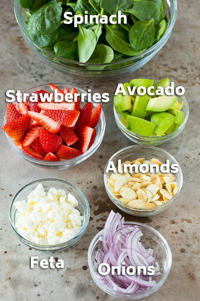 Strawberry Spinach Salad Recipe | Strawberry Salad | Spinach Salad #spinach #salad #strawberries #avocado #sadud Bowls of ingredients like feta cheese, almonds, red onion and avocado.