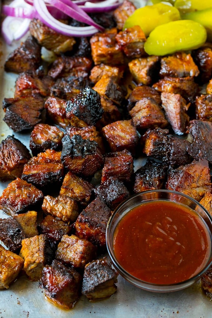 Burnt Ends Recipe | Smoked Brisket | Beef Brisket #brisket #bbq #smoker #beef #dinner #sadud Burnt ends on a sheet pan served with BBQ sauce, red onions and pickles.