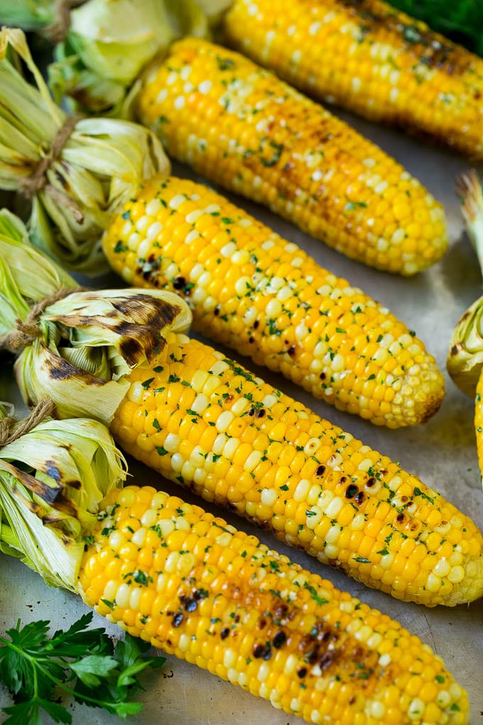 Grilled Corn on the Cob Recipe | Corn Recipe #corn #grilling #summer #sidedish #dinner #sadud Grilled corn on the cob topped with garlic and herb butter on a sheet pan.