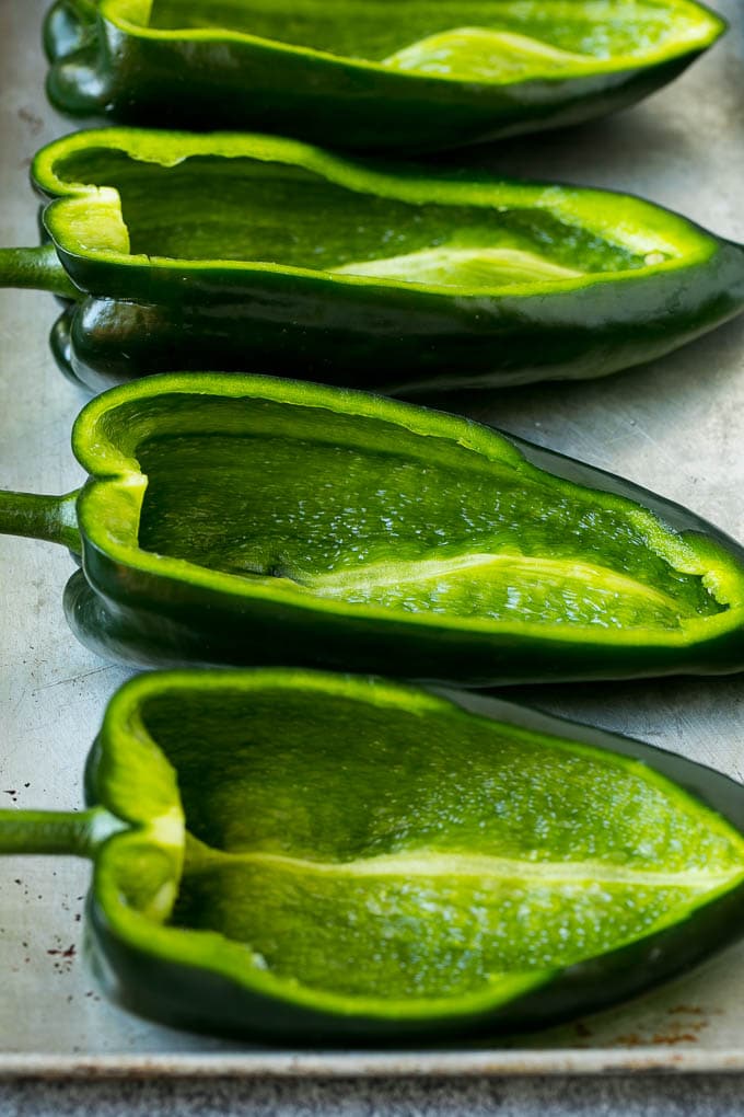 Stuffed Poblano Peppers | Stuffed Peppers | Pasilla Peppers #peppers #stuffedpeppers #beef #rice #beans #corn #dinner #sadud Hollowed out poblano peppers on a pan.