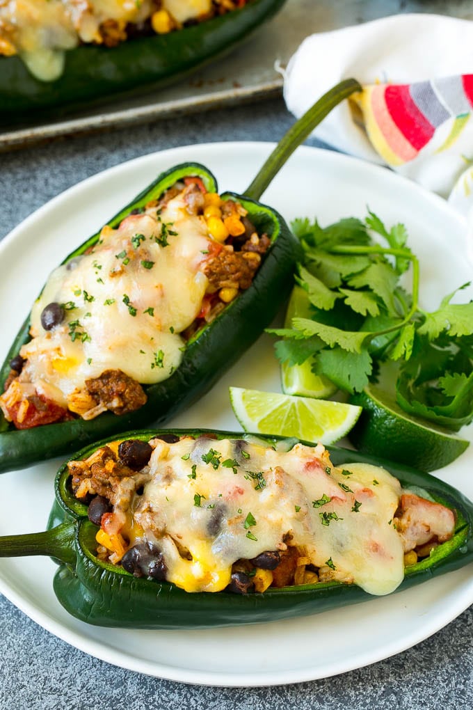 Stuffed Poblano Peppers | Stuffed Peppers | Pasilla Peppers #peppers #stuffedpeppers #beef #rice #beans #corn #dinner #sadud A plate of stuffed poblano peppers topped with melted cheese.