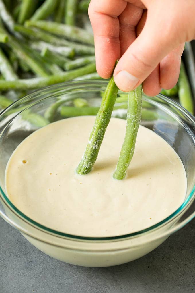 Fried Green Beans Recipe | Green Beans #greenbeans #appetizer #snack #sadud A hand dipping beans into beer batter.
